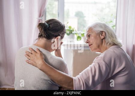 Je suis avec toi mon bébé. Aimant vieille maman mature assis sur le canapé Banque D'Images