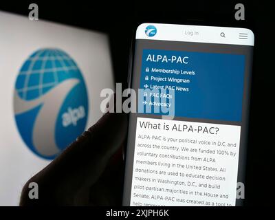 Stuttgart, Allemagne, 06-17-2023 : personne tenant un téléphone portable avec la page Web de l'Association internationale des pilotes de ligne aérienne (ALPA) sur l'écran avec le logo. Mise au point Banque D'Images