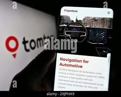 Stuttgart, Allemagne, 06-17-2023 : personne tenant un smartphone avec la page web de la société néerlandaise de technologie de localisation TomTom NV sur l'écran avec logo. Concentrez-vous sur Banque D'Images