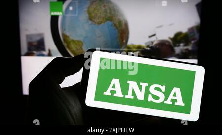 Stuttgart, Allemagne, 06-18-2023 : personne tenant un téléphone portable avec le logo de l'ANSA sur l'écran devant la page web. Concentrez-vous sur l'affichage du téléphone Banque D'Images