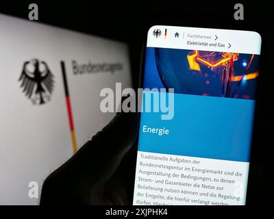 Stuttgart, Allemagne, 06-24-2023 : personne tenant un smartphone avec la page web de l'autorité allemande Bundesnetzagentur (BNetzA) sur l'écran avec le logo. Concentrez-vous sur Banque D'Images