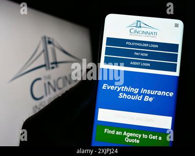 Stuttgart, Allemagne : 06-25-2023 : personne tenant un smartphone avec la page web de la société américaine Cincinnati Financial Corporation sur l'écran avec le logo. Concentrez-vous sur Banque D'Images