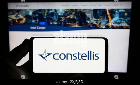 Stuttgart, Allemagne, 07-01-2023 : personne tenant un smartphone avec le logo de la société de sécurité américaine Constellis Holdings LLC sur l'écran devant le site Web. Banque D'Images