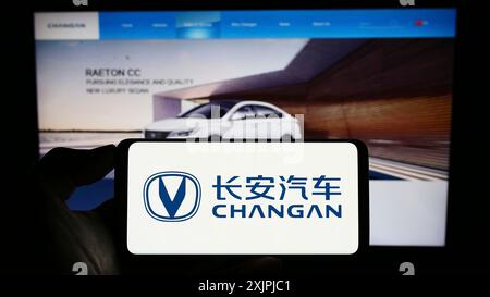 Stuttgart, Allemagne, 06-30-2023, personne tenant un smartphone avec le logo de la société chinoise Changan automobile Co. Ltd sur l'écran devant le site Web. Banque D'Images