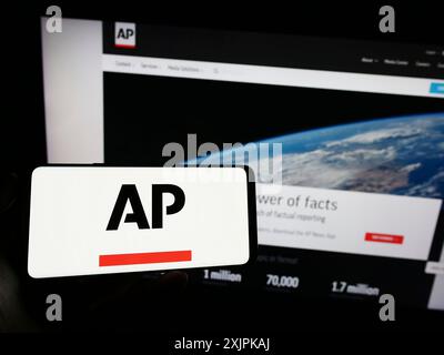 Stuttgart, Allemagne, 07-11-2023 : personne tenant un téléphone portable avec le logo de l'agence de presse américaine Associated Press (AP) sur l'écran devant la page web. Concentrez-vous sur Banque D'Images