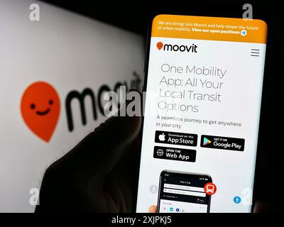 Stuttgart, Allemagne, 07-12-2023 : personne tenant un téléphone portable avec la page web de la société de mobilité israélienne Moovit Inc sur l'écran devant le logo. Concentrez-vous sur Banque D'Images