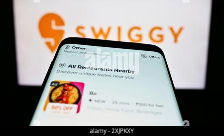 Stuttgart, Allemagne, 07-15-2023 : téléphone portable avec la page Web de la société indienne de livraison de nourriture Swiggy sur l'écran devant le logo de l'entreprise. Concentrez-vous sur Banque D'Images