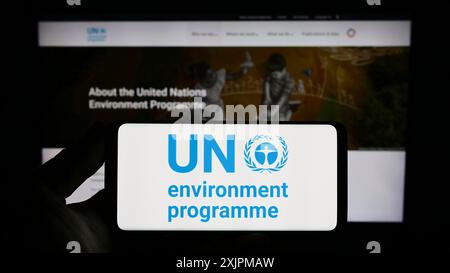 Stuttgart, Allemagne, 07 27 2023 : personne tenant un smartphone avec le logo du Programme des Nations Unies pour l'environnement (PNUE) sur l'écran devant le site Web. Banque D'Images