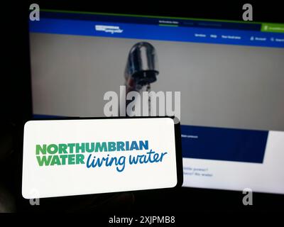 Stuttgart, Allemagne, 07-25-2023, personne tenant un smartphone avec le logo de la société britannique Northumbrian Water Limited sur l'écran devant le site Web. Banque D'Images