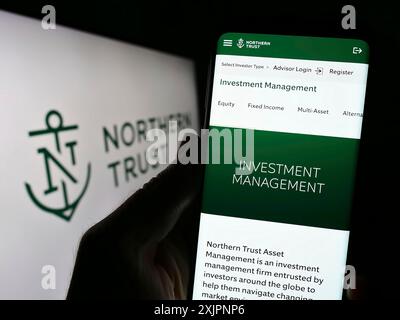 Stuttgart, Allemagne, 08-06-2023 : personne tenant le téléphone portable avec la page Web de la société financière américaine Northern Trust Corporation sur l'écran avec le logo. Mise au point Banque D'Images