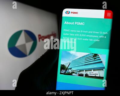 Stuttgart, Allemagne, 08-06-2023 : personne tenant un smartphone avec la page web de la société Powerchip Technology Corporation (PSMC) sur l'écran avec le logo. Mise au point Banque D'Images