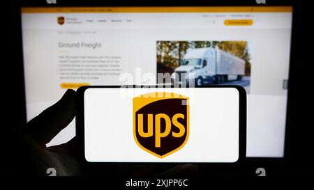 Stuttgart, Allemagne, 08-11-2023 : personne tenant un smartphone avec le logo de la société américaine United Parcel Service Inc (UPS) sur l'écran devant le site Web. Banque D'Images