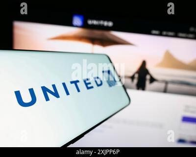 Stuttgart, Allemagne, 08-11-2023 : smartphone avec le logo de la société américaine United Airlines Holdings Inc sur l'écran devant le site Web de l'entreprise. Mise au point Banque D'Images