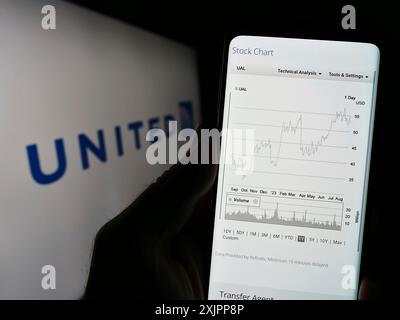 Stuttgart, Allemagne, 08-11-2023 : personne tenant un téléphone portable avec la page web de la société américaine United Airlines Holdings Inc sur l'écran devant le logo. Mise au point Banque D'Images