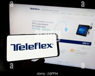 Stuttgart, Allemagne, 08-11-2023 : personne tenant un smartphone avec le logo de la société américaine de dispositifs médicaux Teleflex Incorporated sur l'écran devant Banque D'Images