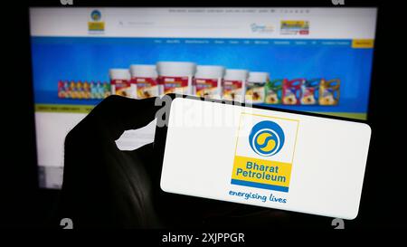 Stuttgart, Allemagne, 08-13-2023 : personne tenant un smartphone avec le logo de Bharat Petroleum Corporation Limited (BPCL) sur l'écran devant le site Web. Banque D'Images