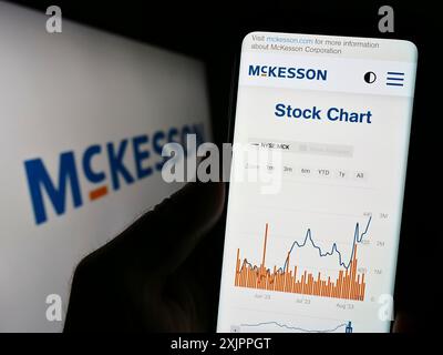 Stuttgart, Allemagne, 08-13-2023 : personne tenant le téléphone portable avec la page Web de la société pharmaceutique américaine McKesson Corporation sur l'écran avec le logo. Mise au point Banque D'Images