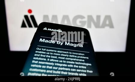 Stuttgart, Allemagne, 08-29-2023, smartphone avec le site de la société automobile Magna International Inc sur l'écran devant le logo de l'entreprise. Concentrez-vous sur Banque D'Images