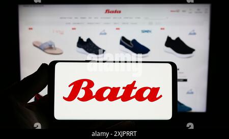 Stuttgart, Allemagne, 08 29 2023 : personne tenant un smartphone avec le logo de la société de chaussures Bata Corporation sur l'écran devant le site Web. Concentrez-vous sur Banque D'Images