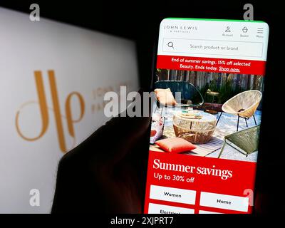 Stuttgart, Allemagne, 08-29-2023, personne tenant un smartphone avec la page Web de la société de vente au détail John Lewis Partnership plc sur l'écran devant le logo. Mise au point Banque D'Images