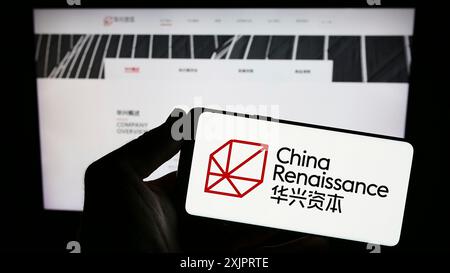 Stuttgart, Allemagne, 08 29 2023 : personne tenant un smartphone avec le logo de la société China Renaissance Holdings Limited sur l'écran devant le site Web. Banque D'Images