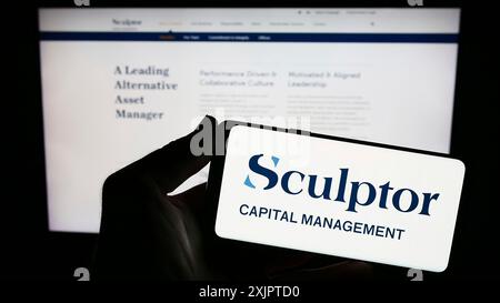 Stuttgart, Allemagne, 09-07-2023 : personne tenant un smartphone avec le logo de la société américaine Sculptor Capital Management Inc sur l'écran devant le site Web. Banque D'Images