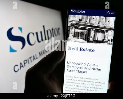 Stuttgart, Allemagne, 09-07-2023 : personne tenant un smartphone avec le site web de la société américaine Sculptor Capital Management Inc sur l'écran avec logo. Concentrez-vous sur Banque D'Images