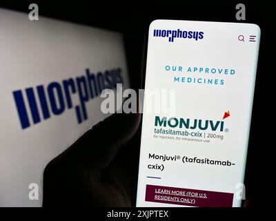 Stuttgart, Allemagne, 09-10-2023 : personne tenant un téléphone portable avec la page web de la société biopharmaceutique allemande MorphoSys AG sur l'écran avec le logo. Concentrez-vous sur Banque D'Images