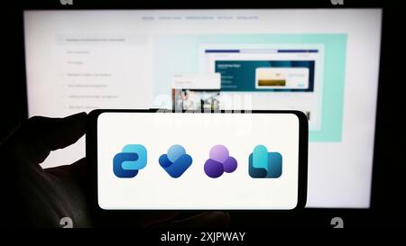 Stuttgart, Allemagne, 09-22-2023 : personne tenant un smartphone avec le logo de la plate-forme d'expérience des employés Microsoft Viva sur l'écran devant le site Web. Banque D'Images