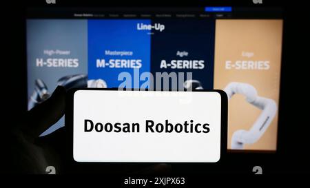 Stuttgart, Allemagne, 09-28-2023, personne tenant un smartphone avec le logo de la société coréenne de robots Doosan Robotics Inc en face du site web. Concentrez-vous sur le téléphone Banque D'Images