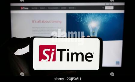 Stuttgart, Allemagne, 09-27-2023, personne tenant un smartphone avec le logo de la société américaine de semi-conducteurs SiTime Corporation devant le site Web. Concentrez-vous sur Banque D'Images