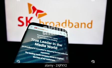 Stuttgart, Allemagne, 10-16-2023 : smartphone avec le site Web de la société coréenne de télécommunications SK Broadband Inc devant le logo de l'entreprise. Concentrez-vous sur Banque D'Images
