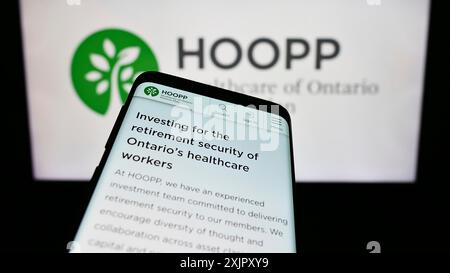 Stuttgart, Allemagne, 10-16-2023 : téléphone mobile avec la page Web du régime de pensions de santé de l'Ontario (HOOPP) devant le logo de l'entreprise. Concentrez-vous sur le coin supérieur gauche Banque D'Images