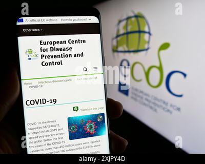 Stuttgart, Allemagne, 10 25 2023 : personne tenant un téléphone portable avec la page web du Centre européen de prévention et de contrôle des maladies (ECDC) avec le logo. Mise au point Banque D'Images