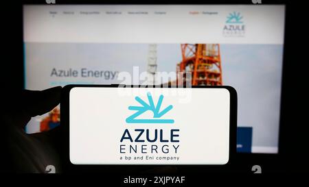 Stuttgart, Allemagne, 10 28 2023 : personne tenant un téléphone portable avec le logo de la compagnie pétrolière angolaise Azule Energy en face de la page web de l'entreprise. Concentrez-vous sur le téléphone Banque D'Images