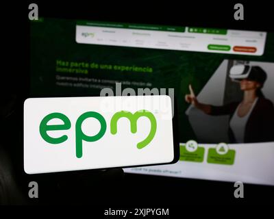 Stuttgart, Allemagne, 10 29 2023 : personne tenant un téléphone portable avec le logo de la société colombienne Empresas Publicas de Medellin (EPM) devant la page web. Banque D'Images