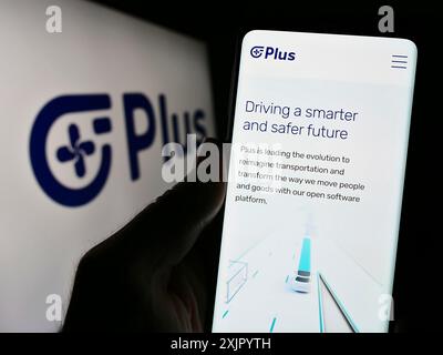 Stuttgart, Allemagne, 10 31 2023 : personne tenant un téléphone portable avec la page Web de la compagnie de camionnage autonome américaine PlusAI Inc devant le logo de l'entreprise. Mise au point Banque D'Images