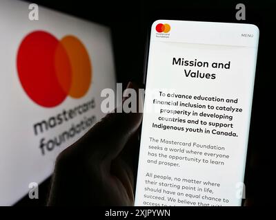 Stuttgart, Allemagne, 11-02-2023 : personne tenant un smartphone avec le site de l'organisation caritative canadienne Mastercard Foundation avec logo. Concentrez-vous sur Banque D'Images