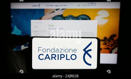 Stuttgart, Allemagne, 11-03-2023 : personne tenant un smartphone avec le logo de la fondation caritative italienne Fondazione Cariplo devant le site web. Concentrez-vous sur Banque D'Images