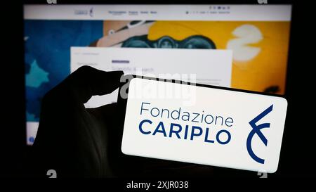 Stuttgart, Allemagne, 11-03-2023 : personne tenant un téléphone portable avec le logo de la fondation caritative italienne Fondazione Cariplo devant la page web. Concentrez-vous sur Banque D'Images