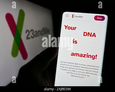 Stuttgart, Allemagne, 11-03-2023 : personne tenant un téléphone portable avec la page web de la société américaine de biotechnologie 23andMe Inc devant le logo de l'entreprise. Concentrez-vous sur Banque D'Images