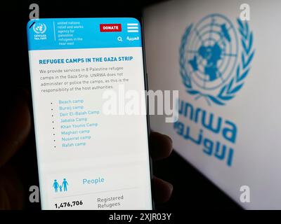 Stuttgart, Allemagne, 11-03-2023 : personne tenant un smartphone avec la page Web de l'agence des Nations Unies Plalestine pour les réfugiés UNRWA devant le logo. Concentrez-vous sur Banque D'Images