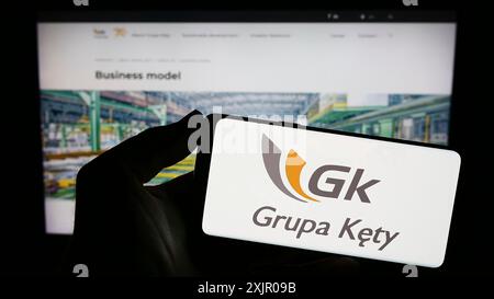 Stuttgart, Allemagne, 11-07-2023 : personne tenant un smartphone avec le logo de la société polonaise d'aluminium Grupa Kety S.A. en face du site. Concentrez-vous sur le téléphone Banque D'Images