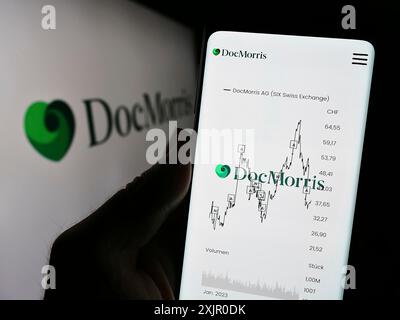 Stuttgart, Allemagne, 11-08-2023 : personne tenant un téléphone portable avec la page web de la société suisse de pharmacie en ligne DocMorris AG devant le logo. Concentrez-vous sur le centre Banque D'Images