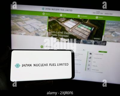 Stuttgart, Allemagne, 11-08-2023 : personne tenant un smartphone avec le logo de la société japonaise d'énergie Japan Nuclear Fuel Ltd (JNFL) devant le site Web. Banque D'Images