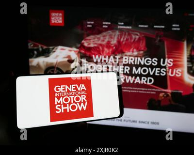 Stuttgart, Allemagne, 11-10-2023 : personne tenant un smartphone avec le logo du salon suisse de l'auto de Genève International Motor Show en face du site. Concentrez-vous sur Banque D'Images