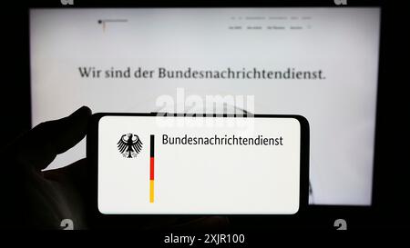 Stuttgart, Allemagne, 11-11-2023 : personne tenant un smartphone avec le logo de l'agence allemande de renseignement Bundesnachrichtendienst (BND) devant le site web. Banque D'Images