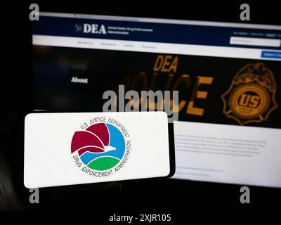 Stuttgart, Allemagne, 11-11-2023 : personne tenant un smartphone avec le sceau de la United States Drug Enforcement Administration (DEA) devant le site Web. Mise au point Banque D'Images