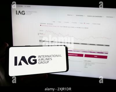 Stuttgart, Allemagne, 11-17-11 2023 : personne tenant un téléphone portable avec le logo d'International Consolidated Airlines Group S.A. (IAG) devant la page Web. Banque D'Images