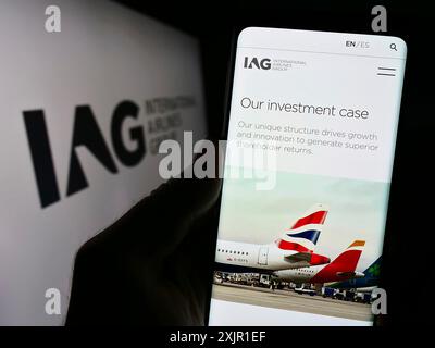 Stuttgart, Allemagne, 11-17-2023 : personne tenant un téléphone portable avec la page Web d'International Consolidated Airlines Group S.A. (IAG) devant le logo. Mise au point Banque D'Images